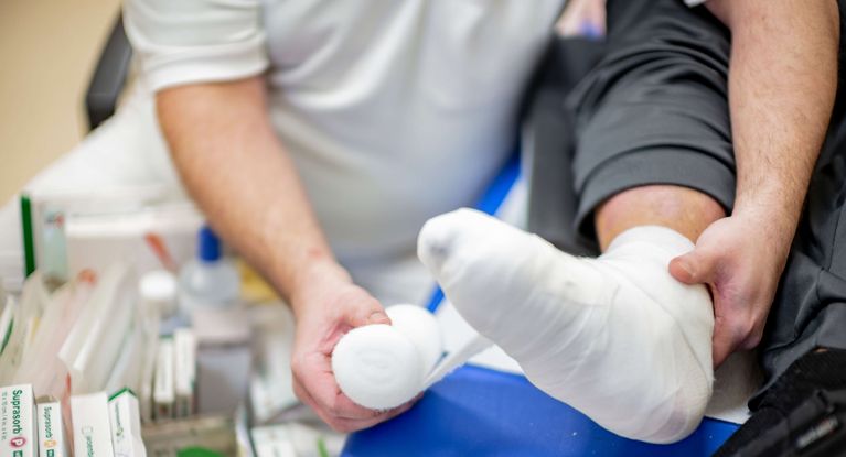 Pflegekraft verbindet Fuß eines Patienten