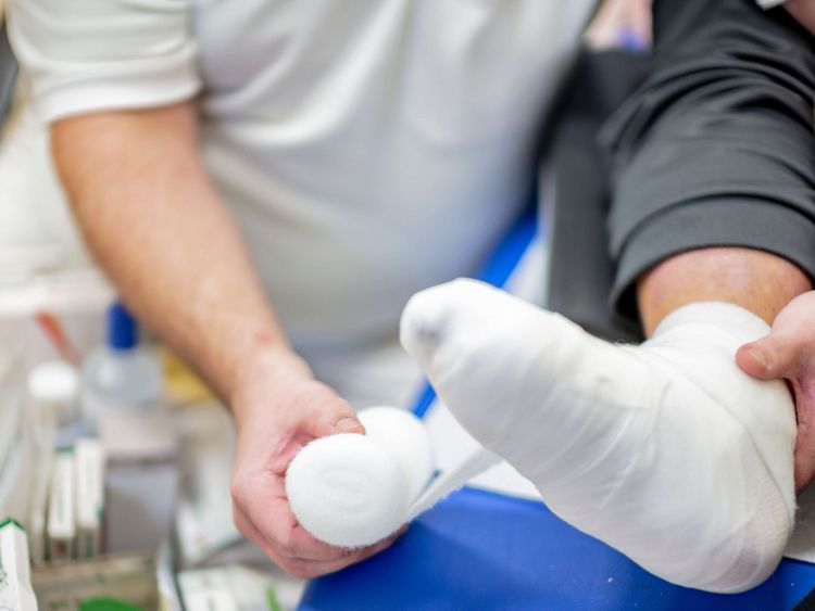 Pflegekraft verbindet Fuß eines Patienten