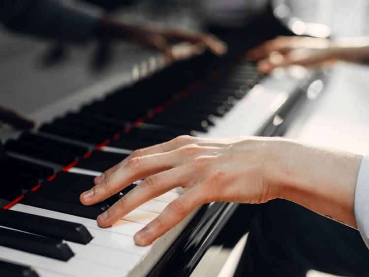 Hände spielen auf einem Klavier