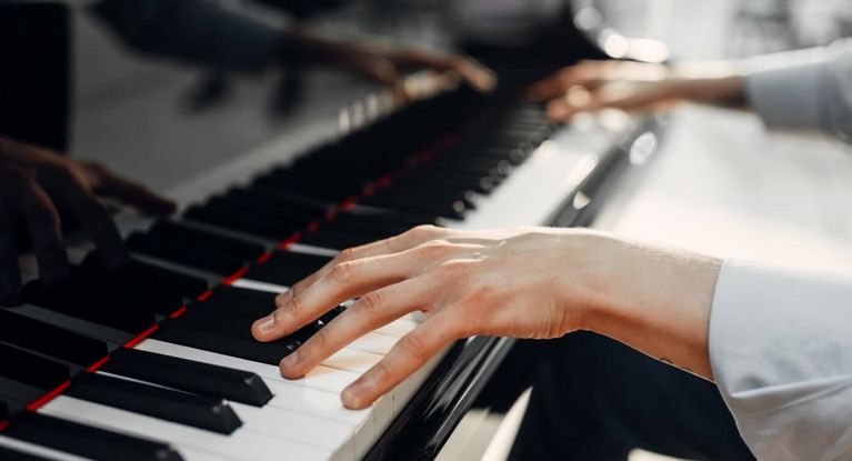 Hände spielen auf einem Klavier