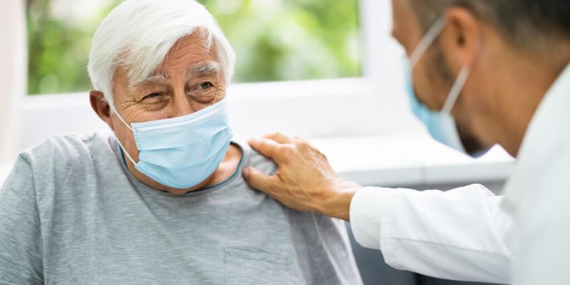 Ein Arzt spricht mit einem älteren Patienten