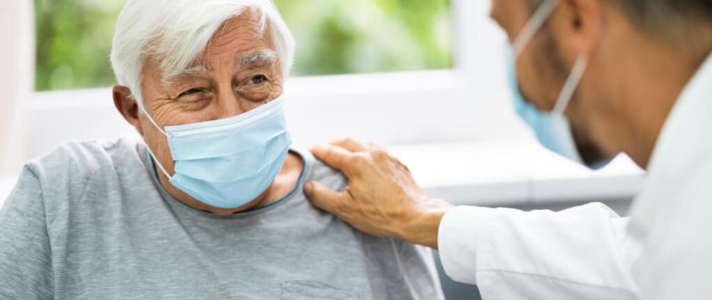 Ein Arzt spricht mit einem älteren Patienten