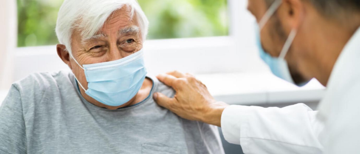 Ein Arzt spricht mit einem älteren Patienten