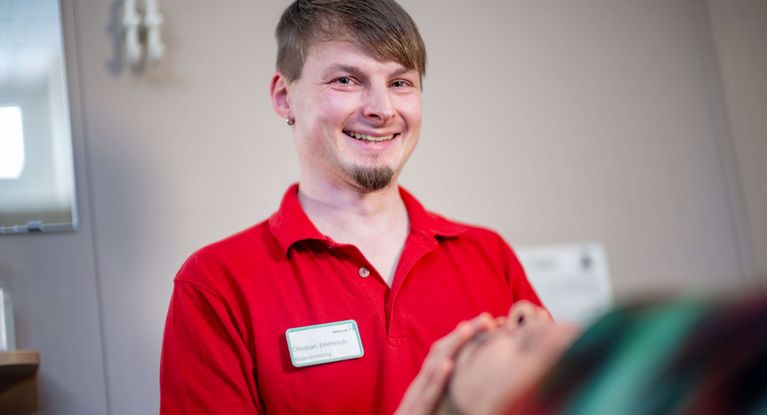 Freundlicher Therapeut massiert Patientin