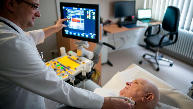 Arzt durchleuchtet Rachen eines Patienten in der Schluckdiagnostik