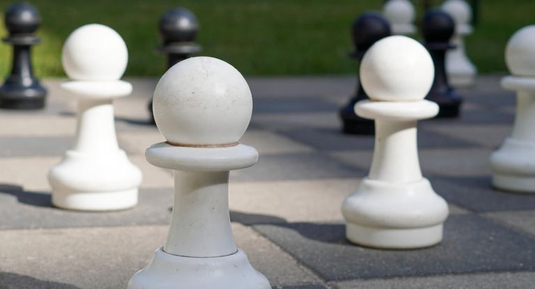 Große Schachfiguren warten im Garten auf die nächste Partie