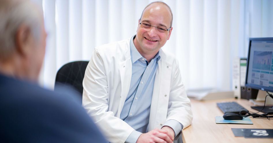 Chefarzt spricht mit geriatrischem Patienten