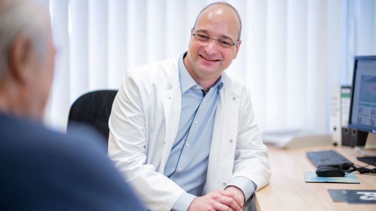 Chefarzt spricht mit geriatrischem Patienten