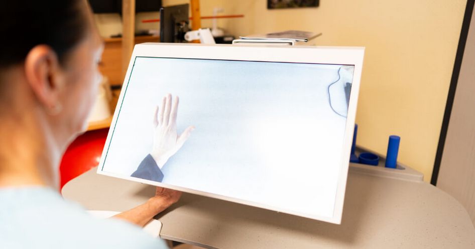 Eine Therapeutin hält ihre Hand unter ein Tyromotion-Gerät