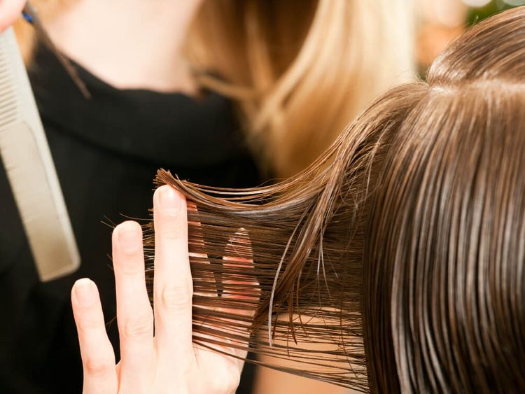 Friseuse ordnet Frisur einer Kundin