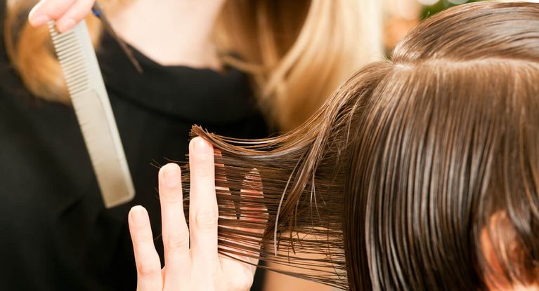 Friseuse ordnet Frisur einer Kundin