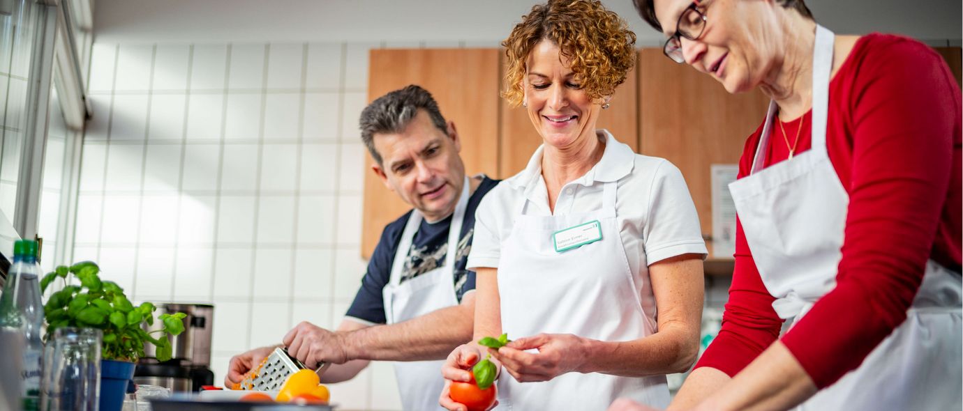 Patienten und Therapeutin kochen in der Lehrküche